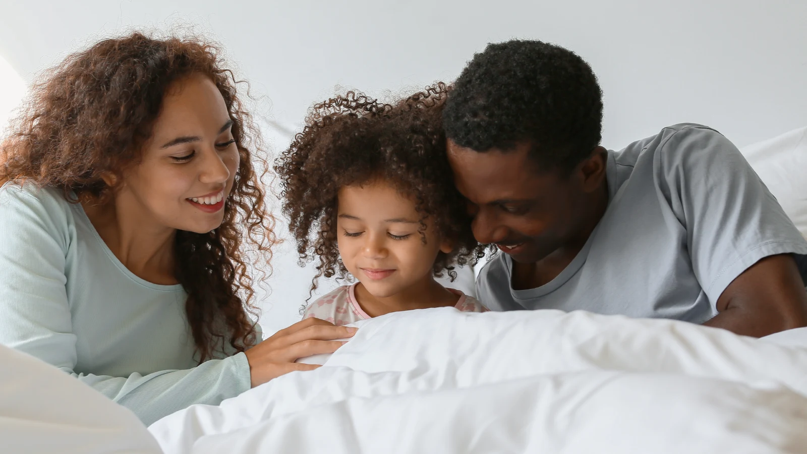 Mother and father preparing her daughter to go to sleep - bedtime routine.