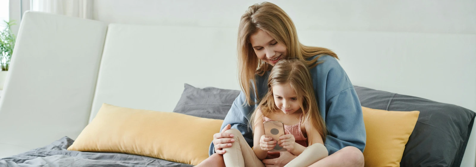 Mom and daughter playing a game on a smartphone to learn english