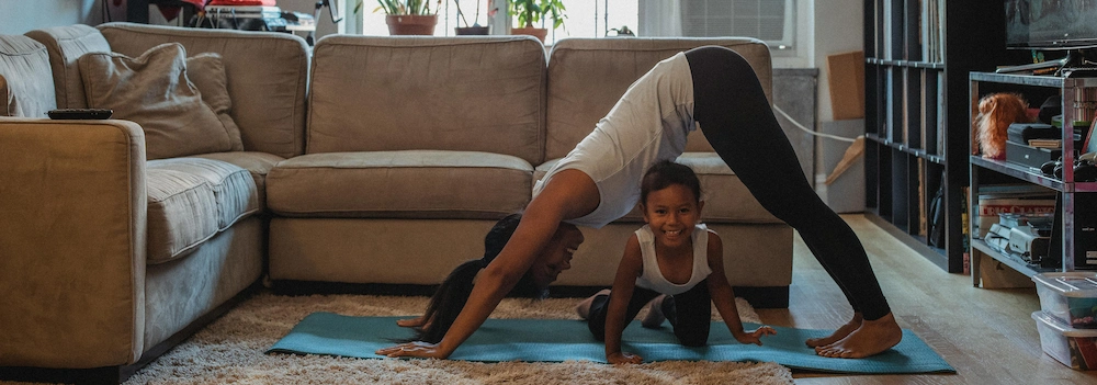 Little girl and mother having fun practising yoga