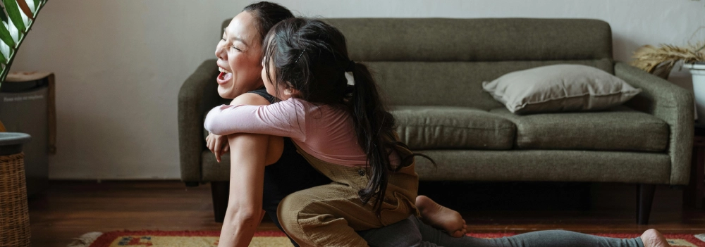 Little girl and mother having fun practising yoga